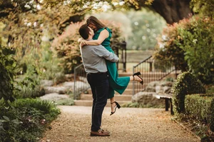 Playful couple lift at botanical garden engagement session