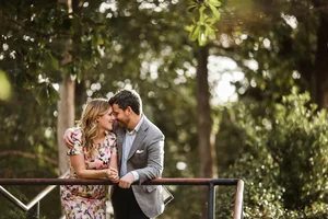 Couple hugging by rail during zoo engagement session