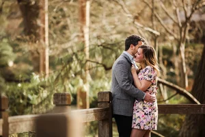 Couple leaning close on zoo bridge during engagement session