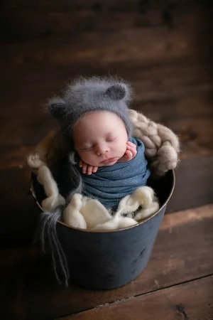Baby boy in blue wrap with bear bonnet
