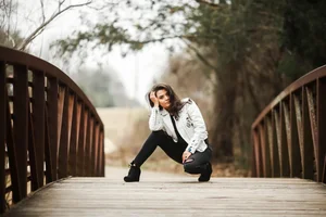 Senior portrait with white jacket on bridge