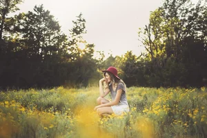 Senior portrait in yellow wildflower field