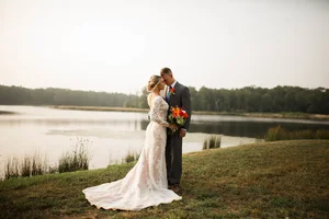 Bride and groom sharing romantic moment by lake in Parker County
