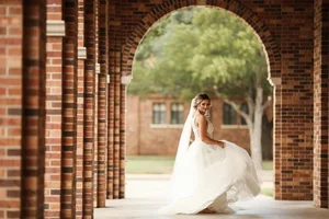 Bride twirling under brick archway in Fort Worth